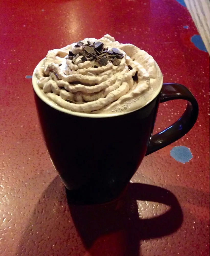 Hot chocolate piled with whipped cream and chocolate shavings