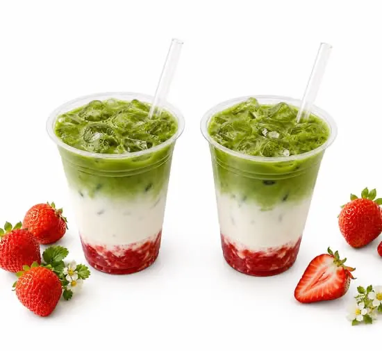 Two iced strawberry matcha lattes with fresh strawberries