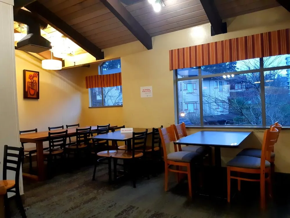 Seating room with wooden beams, big windows and warm terracotta valances