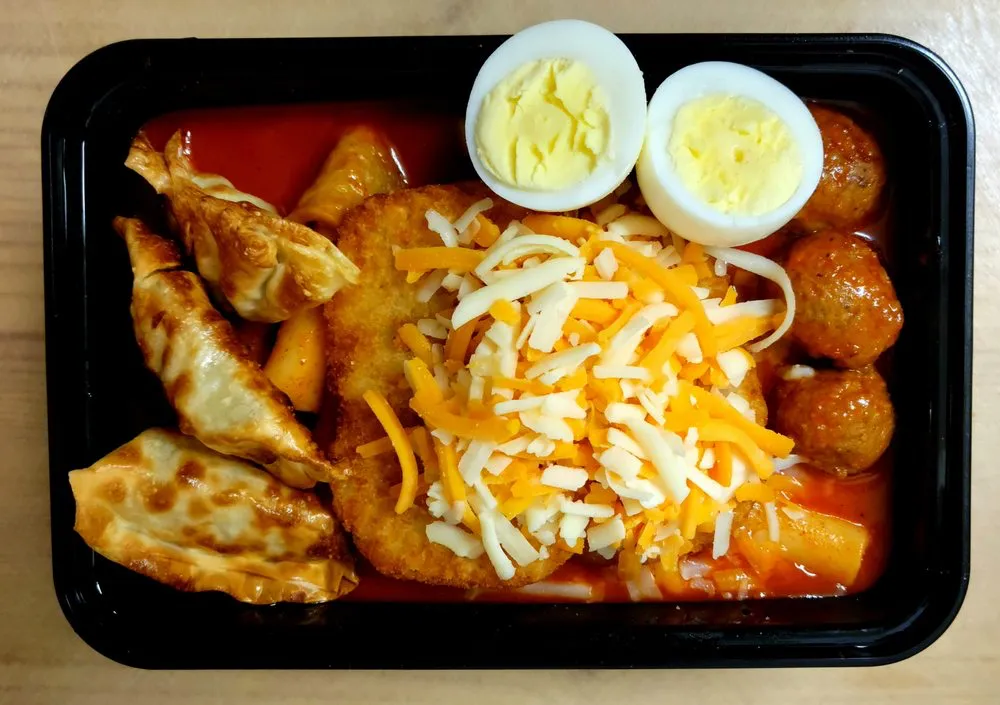 Tteokbokki to go, with dumplings, cheese and halved eggs